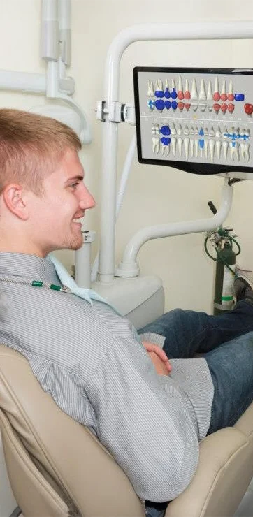 A smiling young patient sitting in a dental exam chair